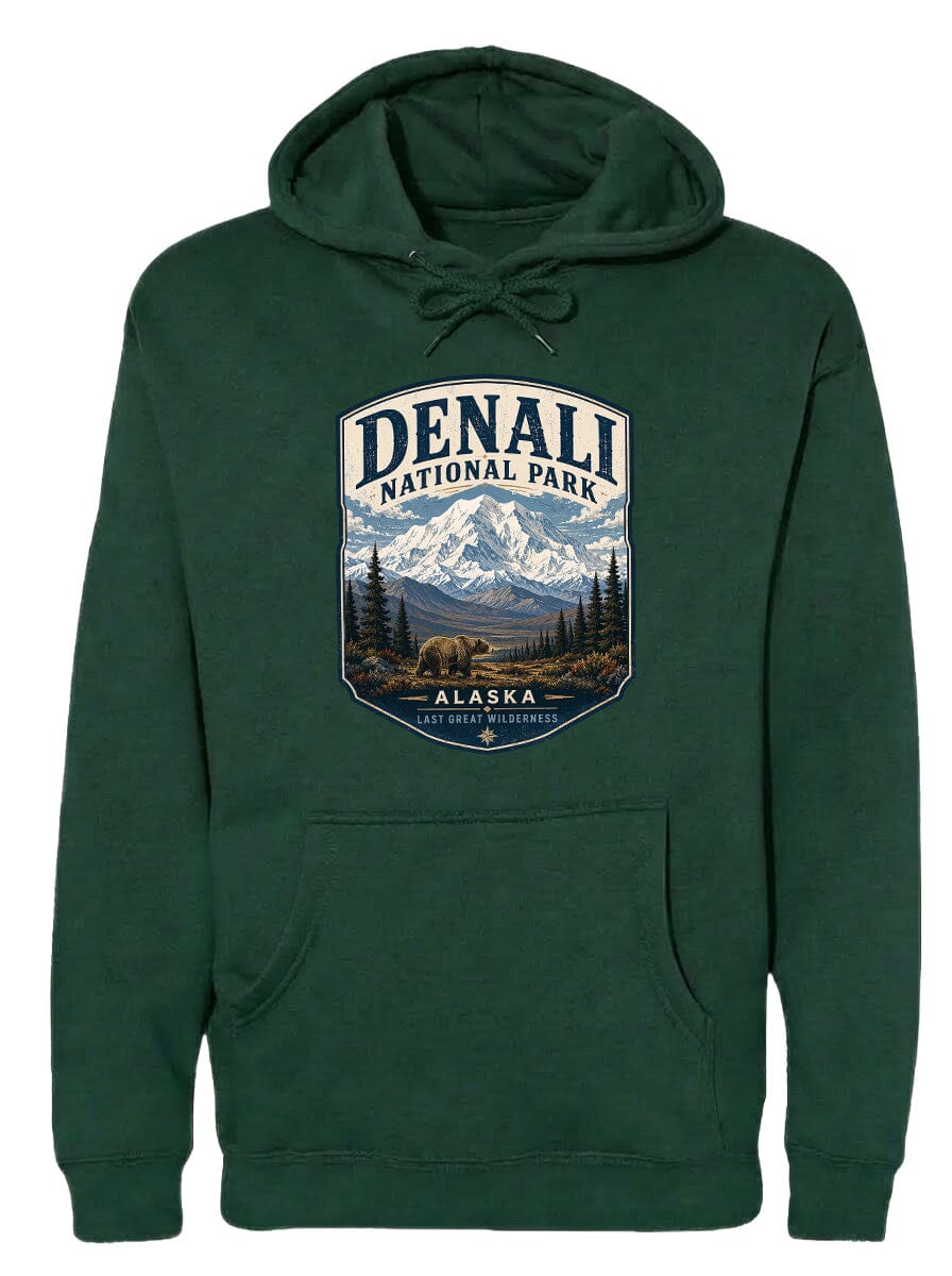 A green hoodie with a graphic design depicting Denali National Park and Alaska, featuring a mountain landscape with a bear in the foreground.