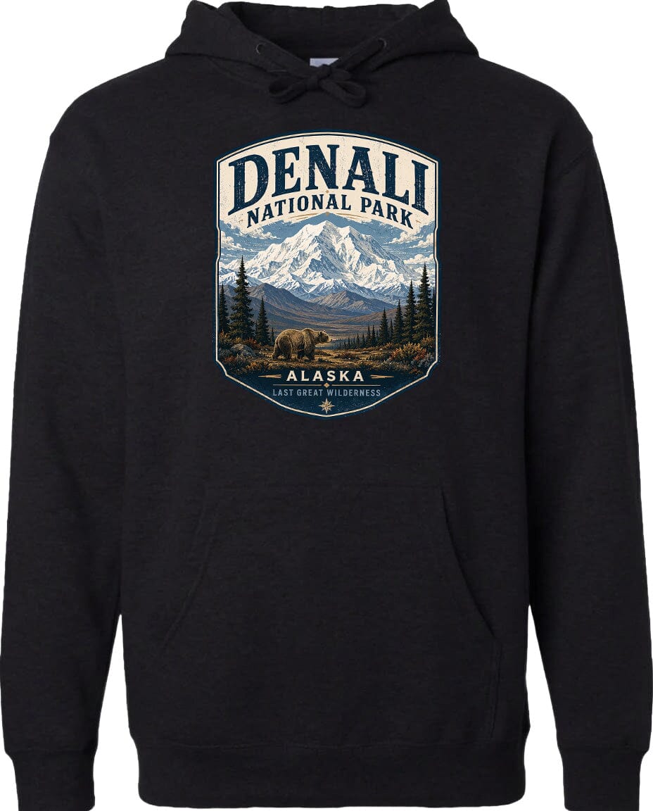 A black hoodie with a graphic design depicting a scenic landscape of Denali National Park in Alaska, featuring a mountain range, pine trees, and a bear.
