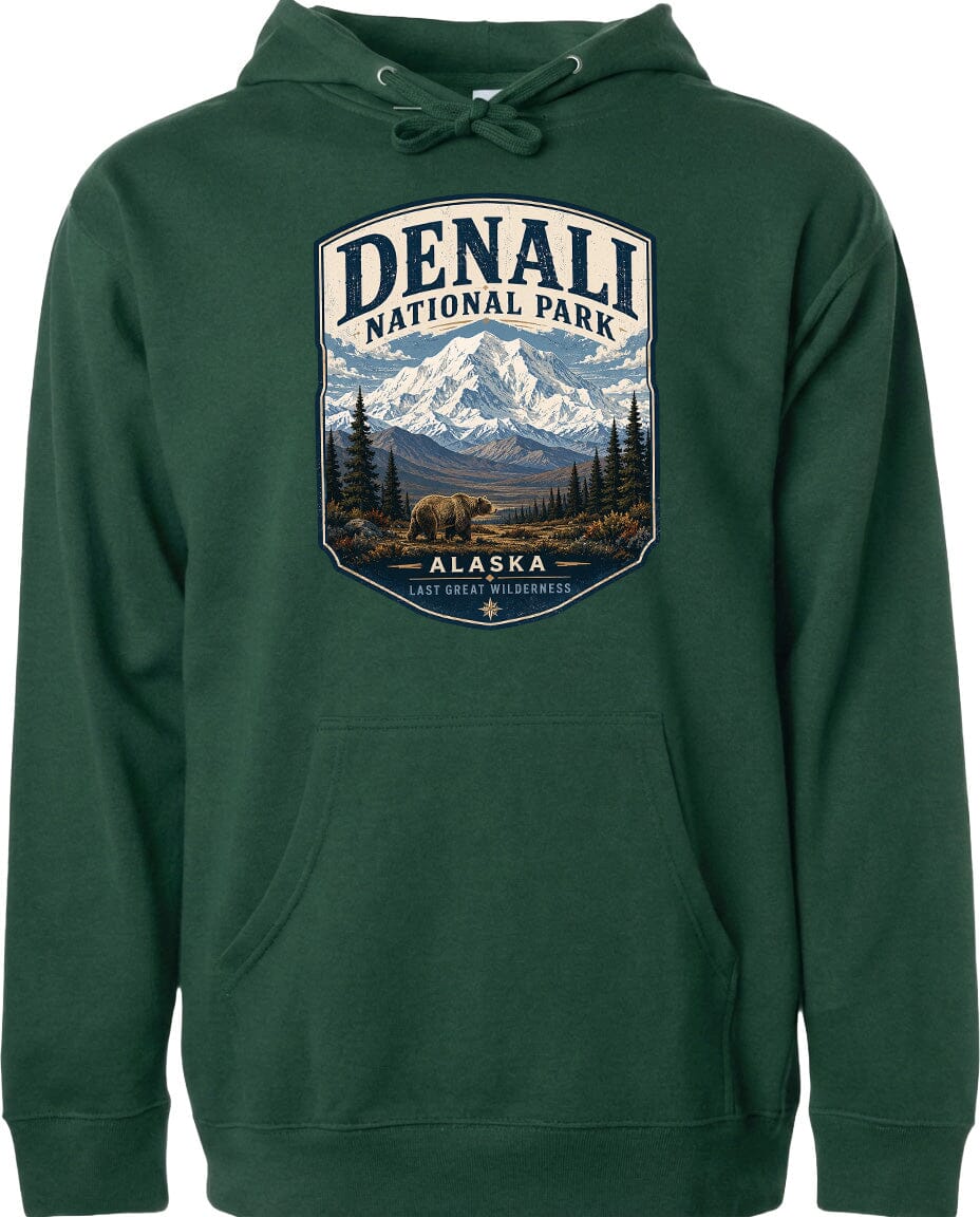 A green hoodie with a graphic design depicting Denali National Park in Alaska, featuring a mountain landscape with a bear in the foreground.