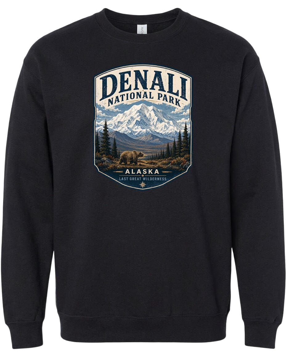 A black sweatshirt with a graphic design depicting a mountain landscape with a bear in the foreground, surrounded by pine trees and mountains.