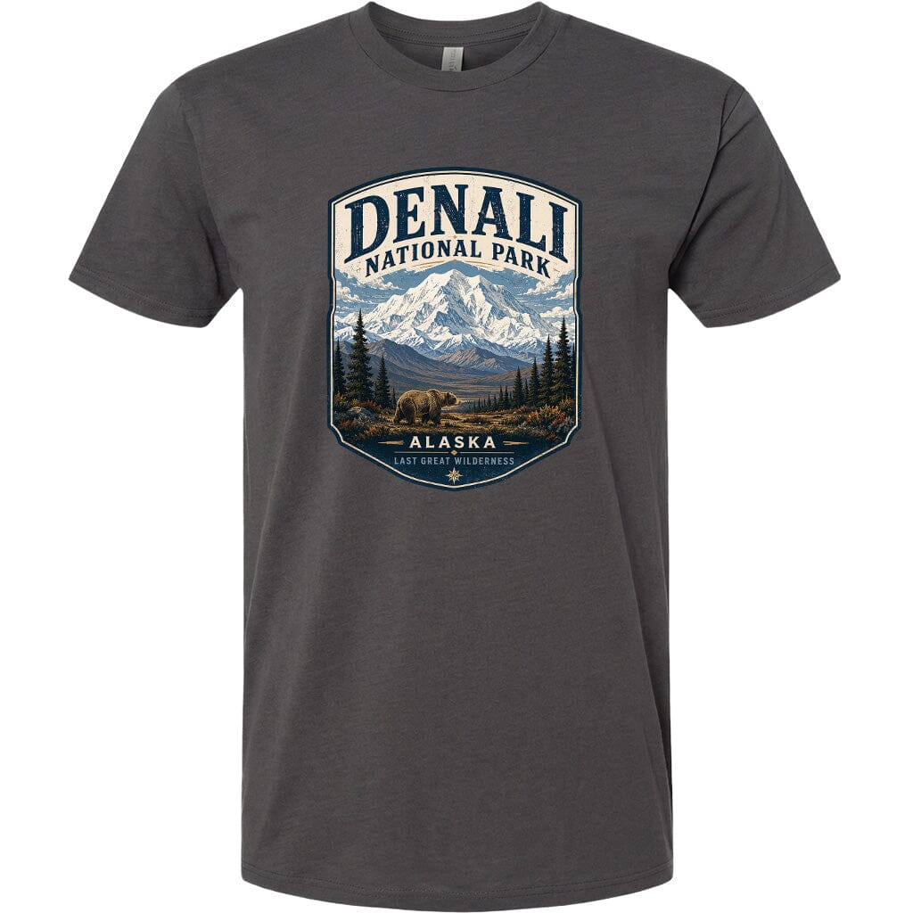 A gray t-shirt with a graphic design featuring a mountain landscape with a bear in the foreground, surrounded by pine trees and mountains.