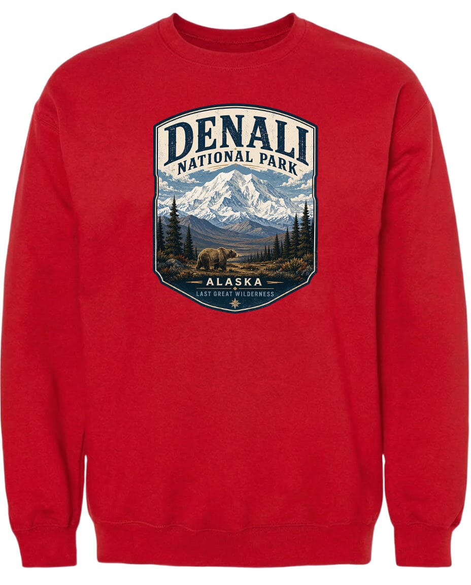 A red sweatshirt with a graphic design depicting a mountain landscape with a bear in the foreground, surrounded by pine trees and mountains.
