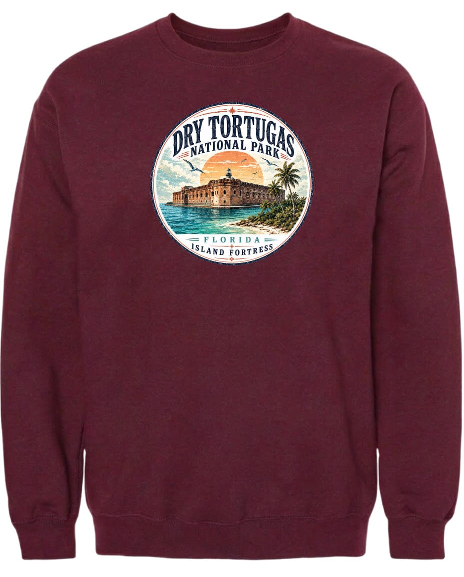 A burgundy-colored sweatshirt with a circular graphic design featuring a building, palm trees, and a sunset over the ocean.