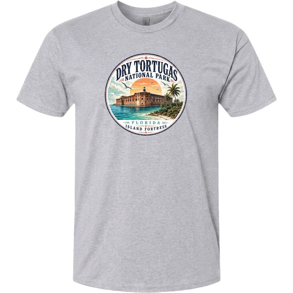 A gray t-shirt with a circular graphic design featuring a building, palm trees, and a sunset over a body of water, representing Dry Tortugas National Park in Florida.