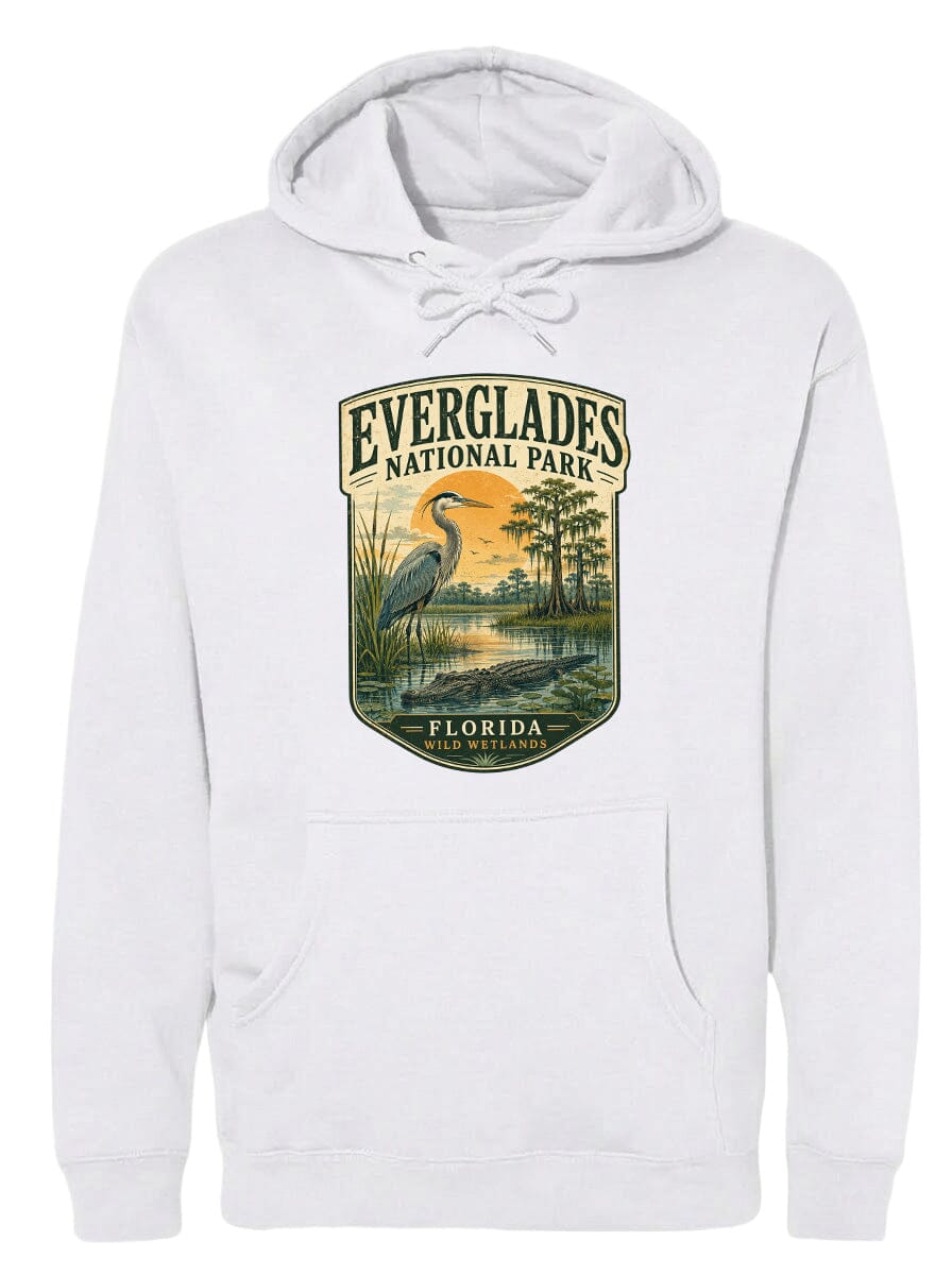 A white hoodie with a graphic design depicting a bird, likely a heron, standing in a marshy area with trees and a sunset in the background.