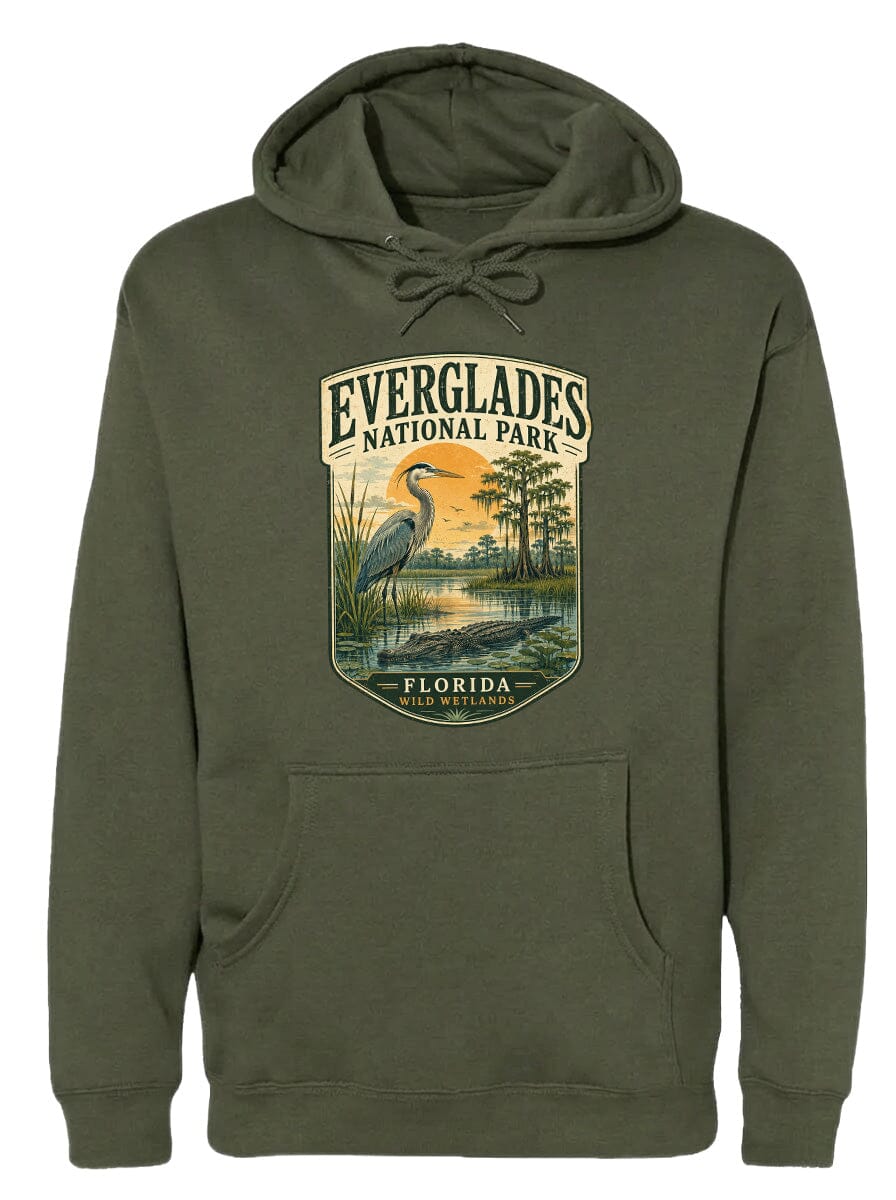 A green hoodie with a graphic design depicting a bird, likely a heron, standing in a marshy area with trees and a sunset in the background.
