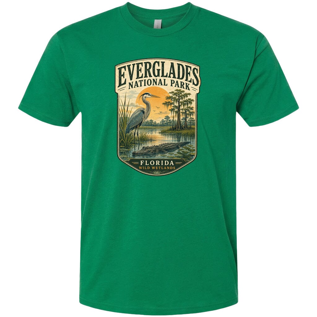 A green t-shirt with a graphic design depicting a bird, a water body, and a landscape with trees and a body of water.