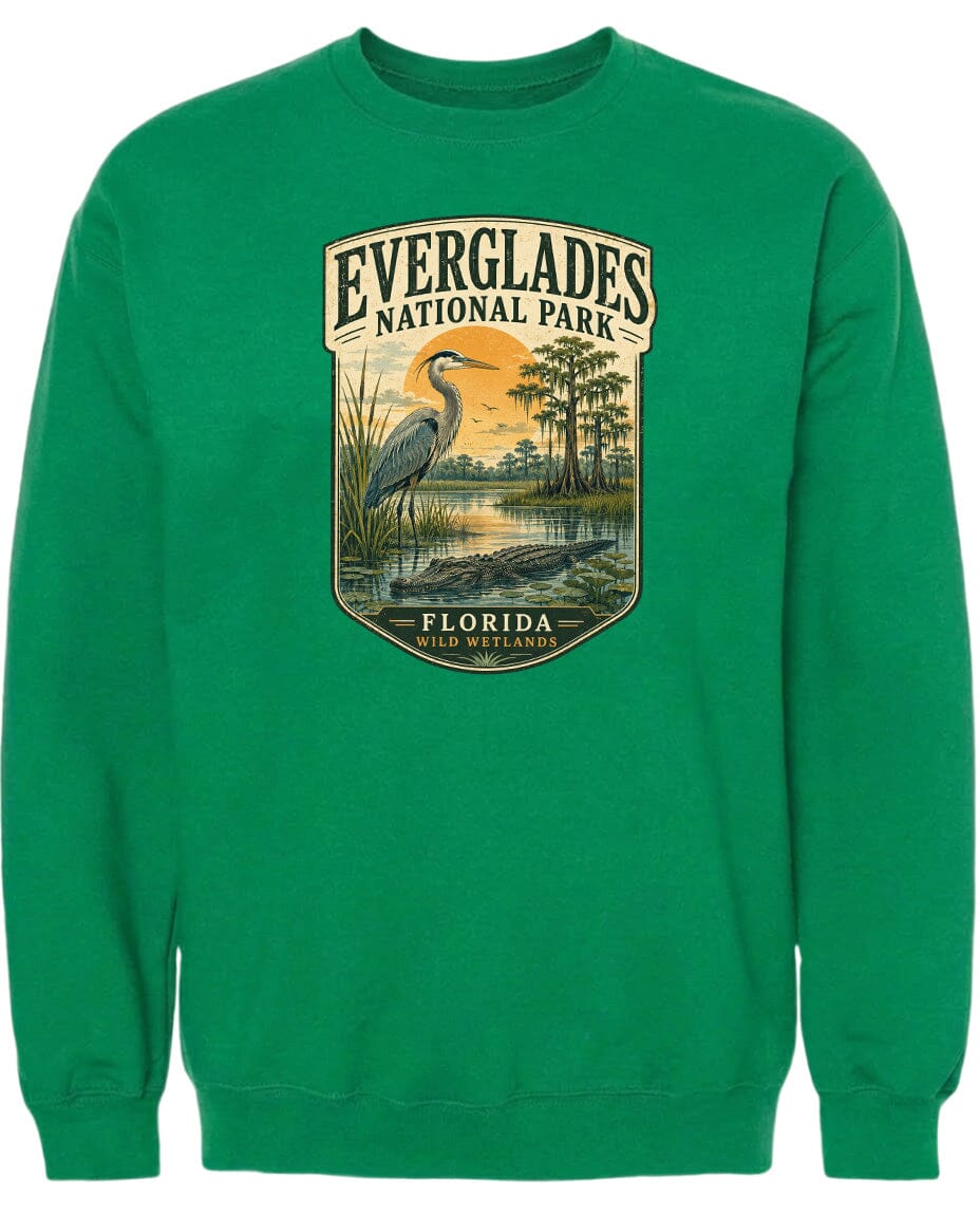A green sweatshirt with a graphic design depicting a bird, a pond, and trees, along with the text "EVERGLADES NATIONAL PARK FLORIDA WILD WETLANDS".