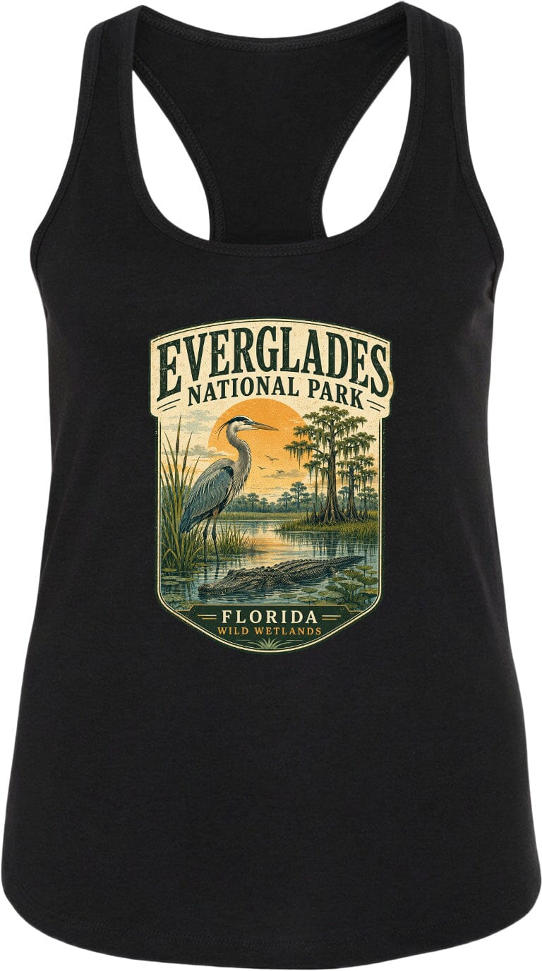 A black tank top with a graphic design depicting a bird, likely a heron, standing in a marshy area with a sunset in the background. The text "EVERGLADES NATIONAL PARK" and "FLORIDA" is visible, indicating the location of the design.
