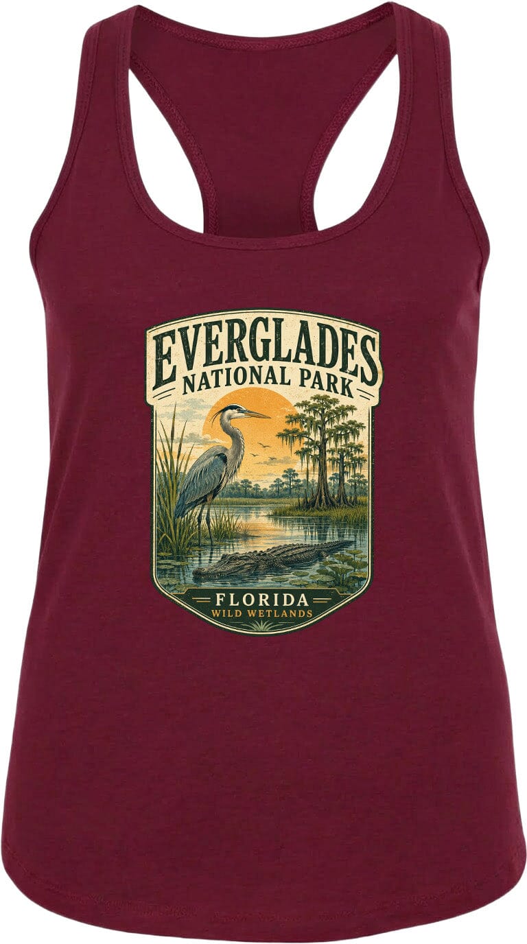 A maroon tank top with a graphic design depicting a bird standing in a marshy area with a sunset in the background, surrounded by trees and water.