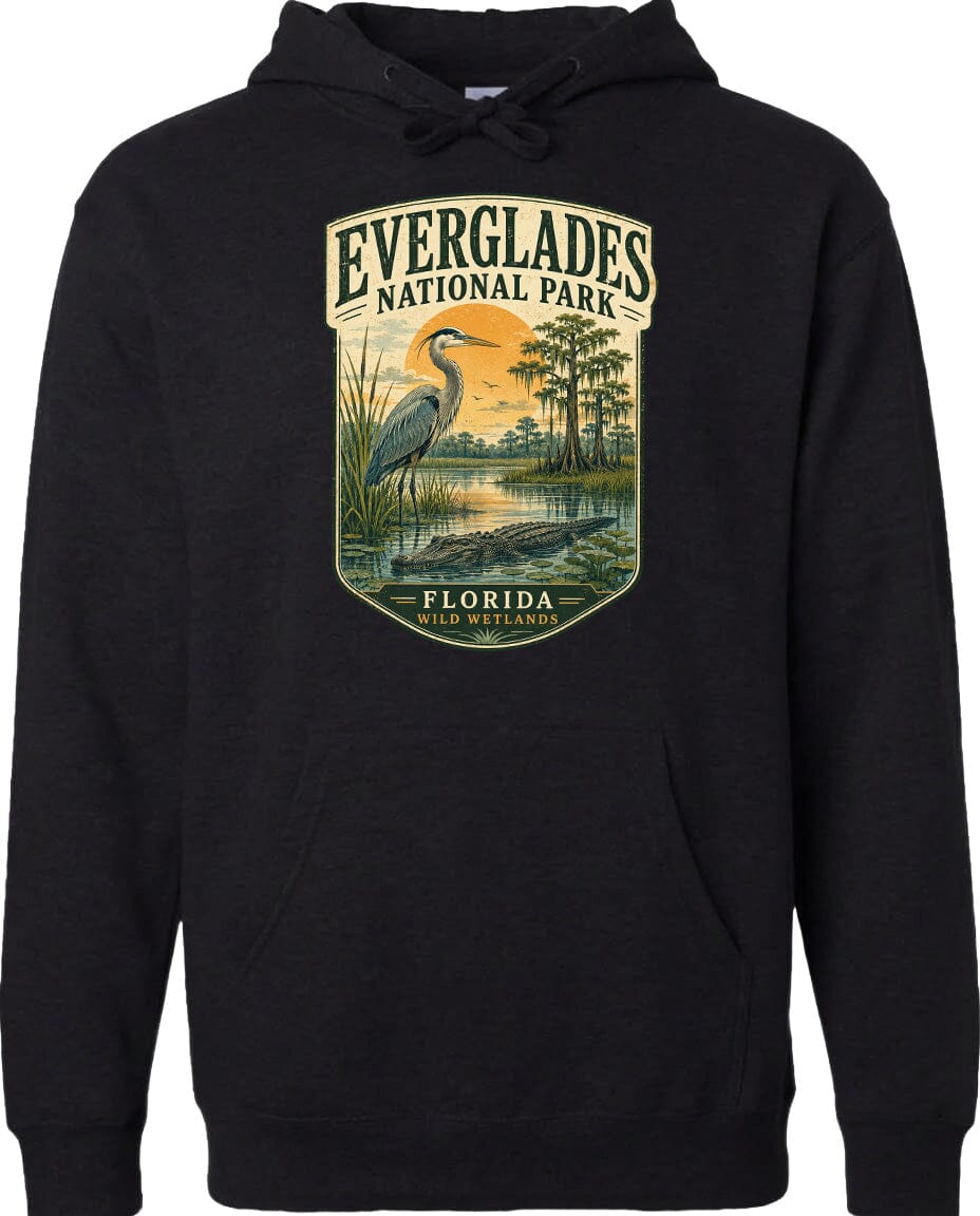 A black hoodie with a graphic design depicting a heron standing in a marshy area with trees and a sunset in the background.