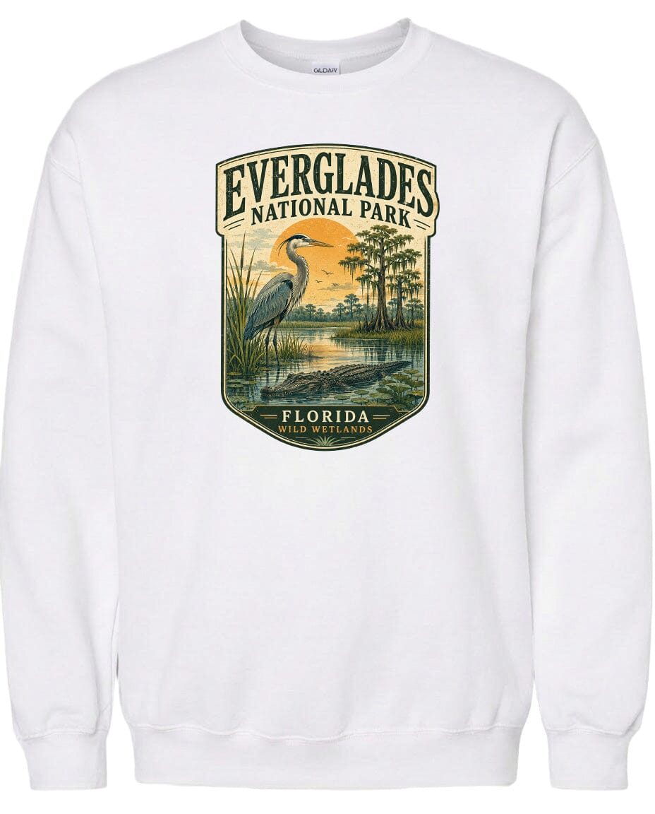 A white sweatshirt with a graphic design depicting a bird, likely a heron, standing in a marshy area with trees and water.