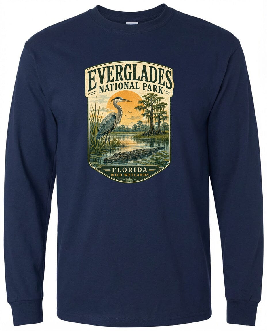 A long-sleeved navy blue t-shirt with a graphic design depicting a heron standing in a marshy area with trees and a sunset in the background.