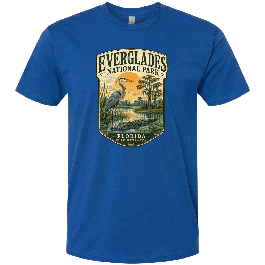 A blue t-shirt with a graphic design depicting a bird, a pond, and trees, along with the text "EVERGLADES NATIONAL PARK FLORIDA WILD WETLANDS".