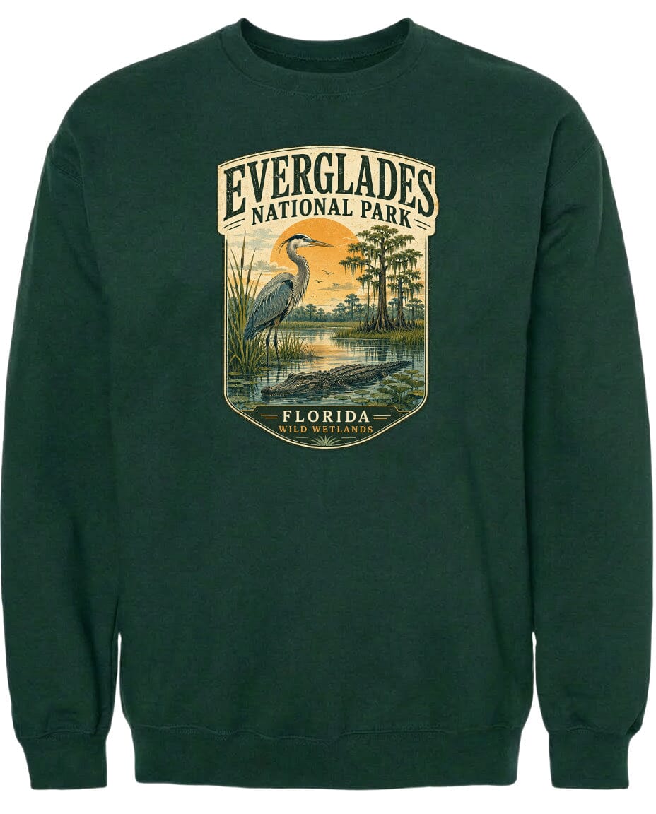 A green sweatshirt with a graphic design depicting a bird, a water body, and trees, along with the text "EVERGLADES NATIONAL PARK FLORIDA WILD WETLANDS".