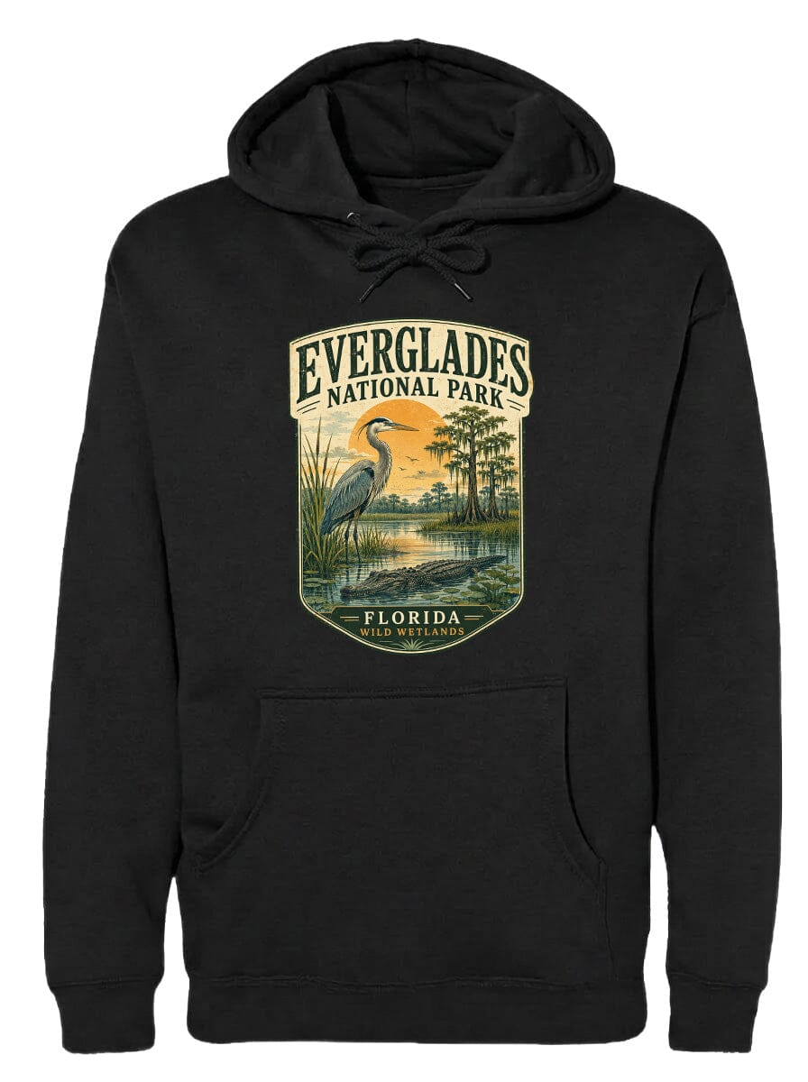 A black hoodie with a graphic design depicting a bird, likely a heron, standing in a marshy area with trees and a sunset in the background.