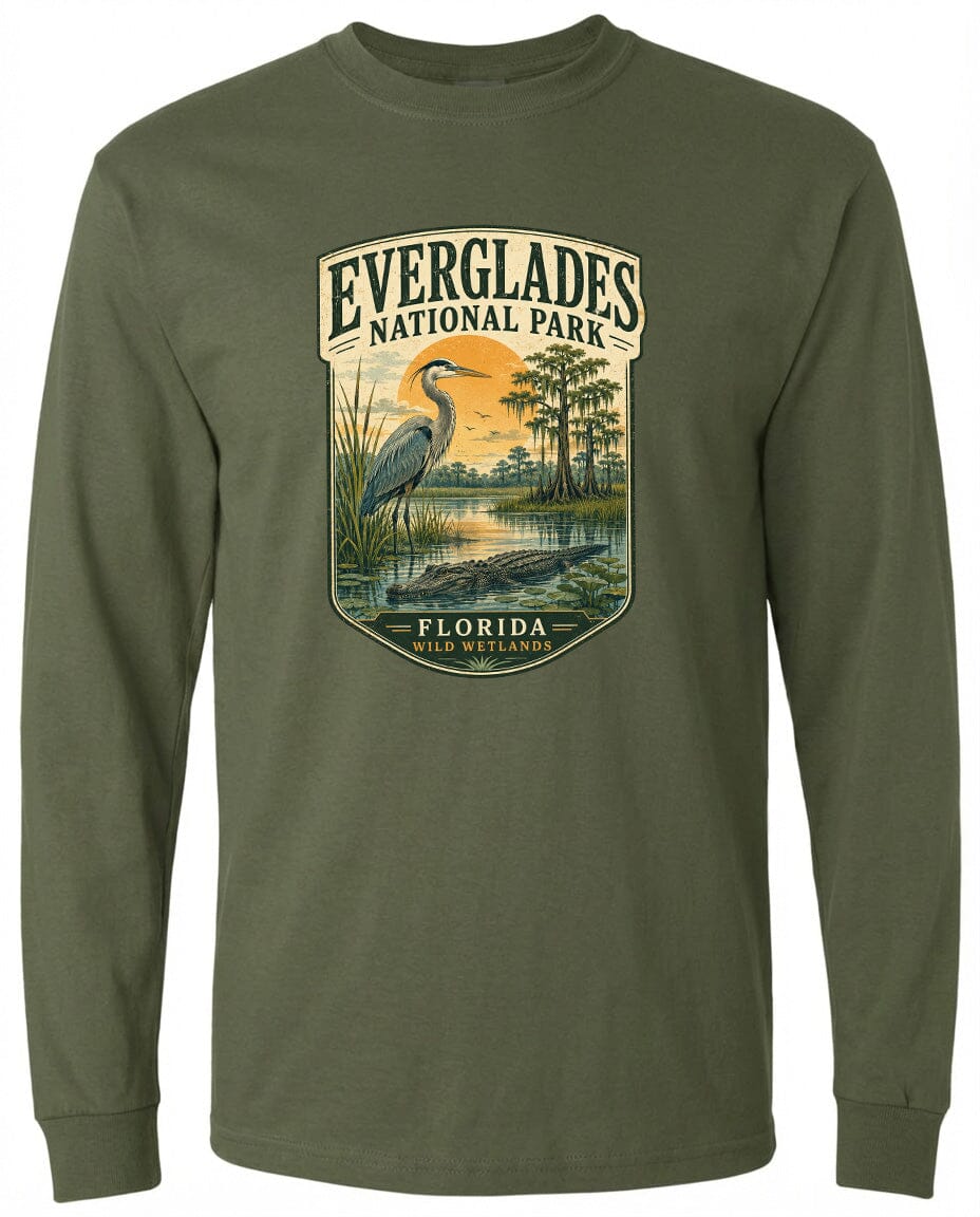 A long-sleeved green t-shirt with a graphic design depicting a bird, a pond, and trees, along with the text "EVERGLADES NATIONAL PARK FLORIDA WILD WETLANDS".