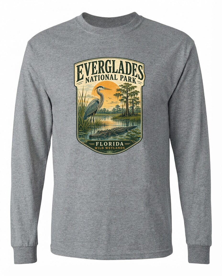 A gray long-sleeved t-shirt with a graphic design depicting a bird, likely a heron, standing in a natural setting with trees and a body of water.