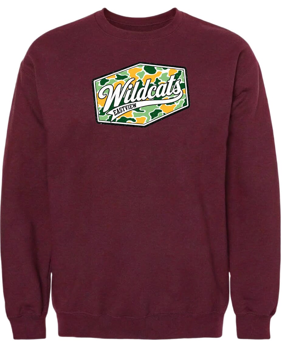 A burgundy-colored sweatshirt with a graphic design on the front. The design features a green and yellow camouflage pattern, and the text "Wildcats" is prominently displayed in a cursive font.