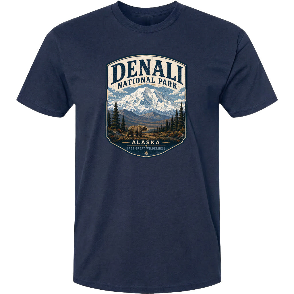 A navy blue t-shirt with a graphic design depicting a mountain landscape with a bear in the foreground, surrounded by pine trees and mountains.