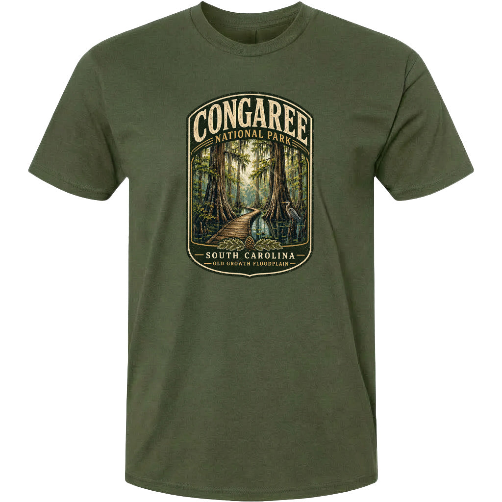 A green t-shirt with a graphic design depicting a forest scene with a path leading through it, surrounded by trees and foliage.