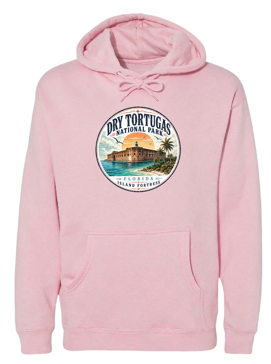 A pink hoodie with a circular design featuring a tropical island with a castle, palm trees, and a sunset.