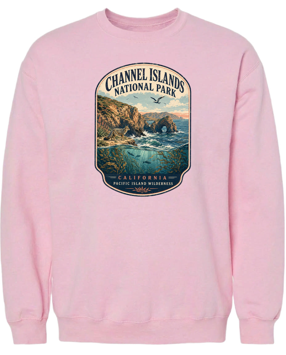 A pink sweatshirt with a graphic design depicting a scenic landscape with cliffs, water, and birds.