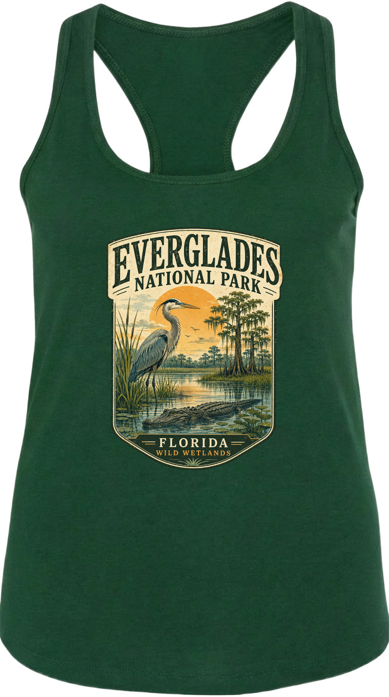 A green tank top with a graphic design depicting a bird, a sunset, and a body of water, along with the text "EVERGLADES NATIONAL PARK FLORIDA WILDER".