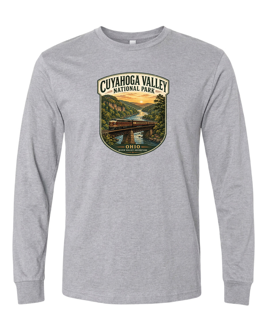 A gray long-sleeved t-shirt with a graphic design depicting a scenic view of the Cuyaohoga Valley National Park, featuring a bridge, trees, and a sunset over a river.