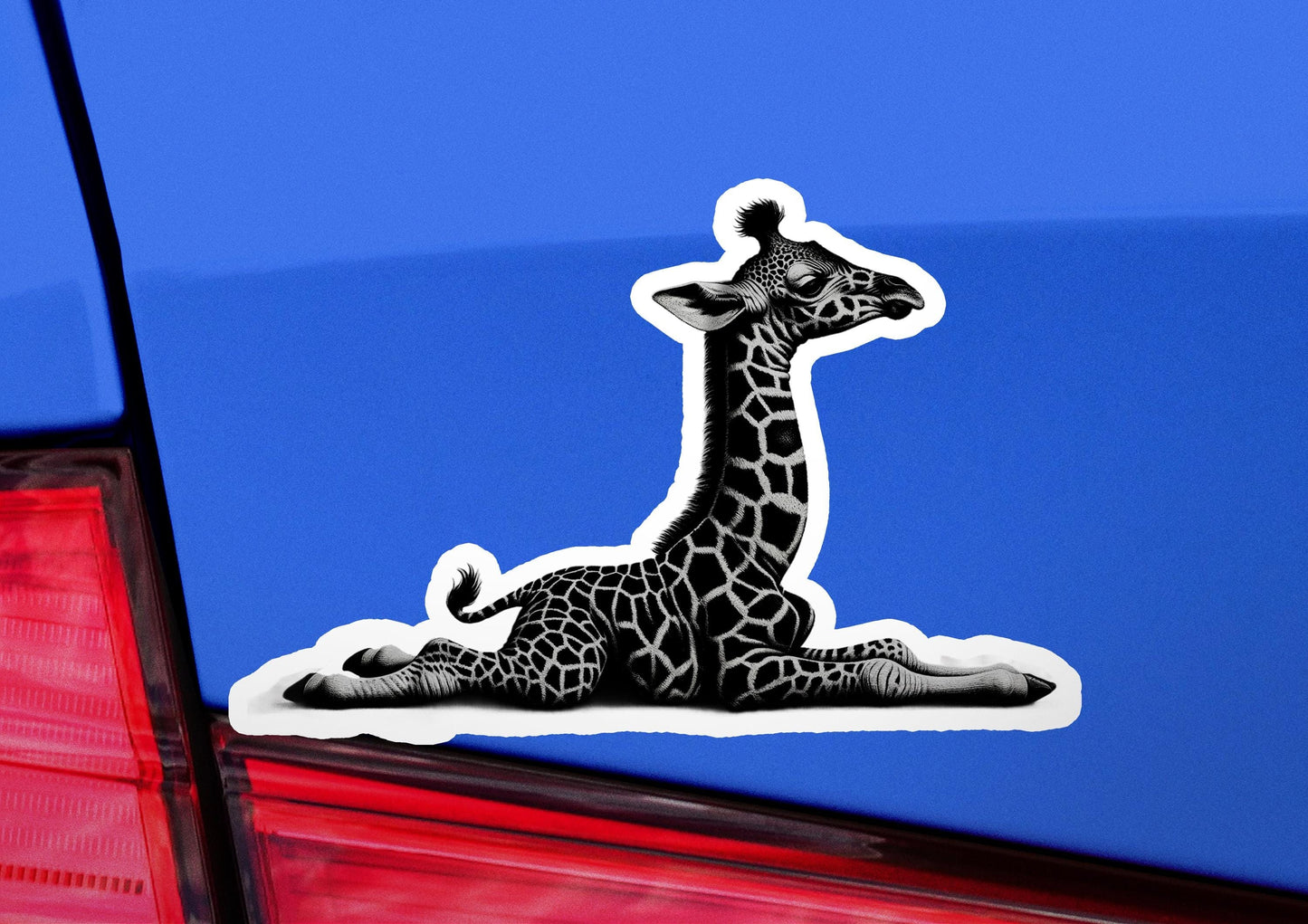 a sticker of a giraffe laying down on the back of a car