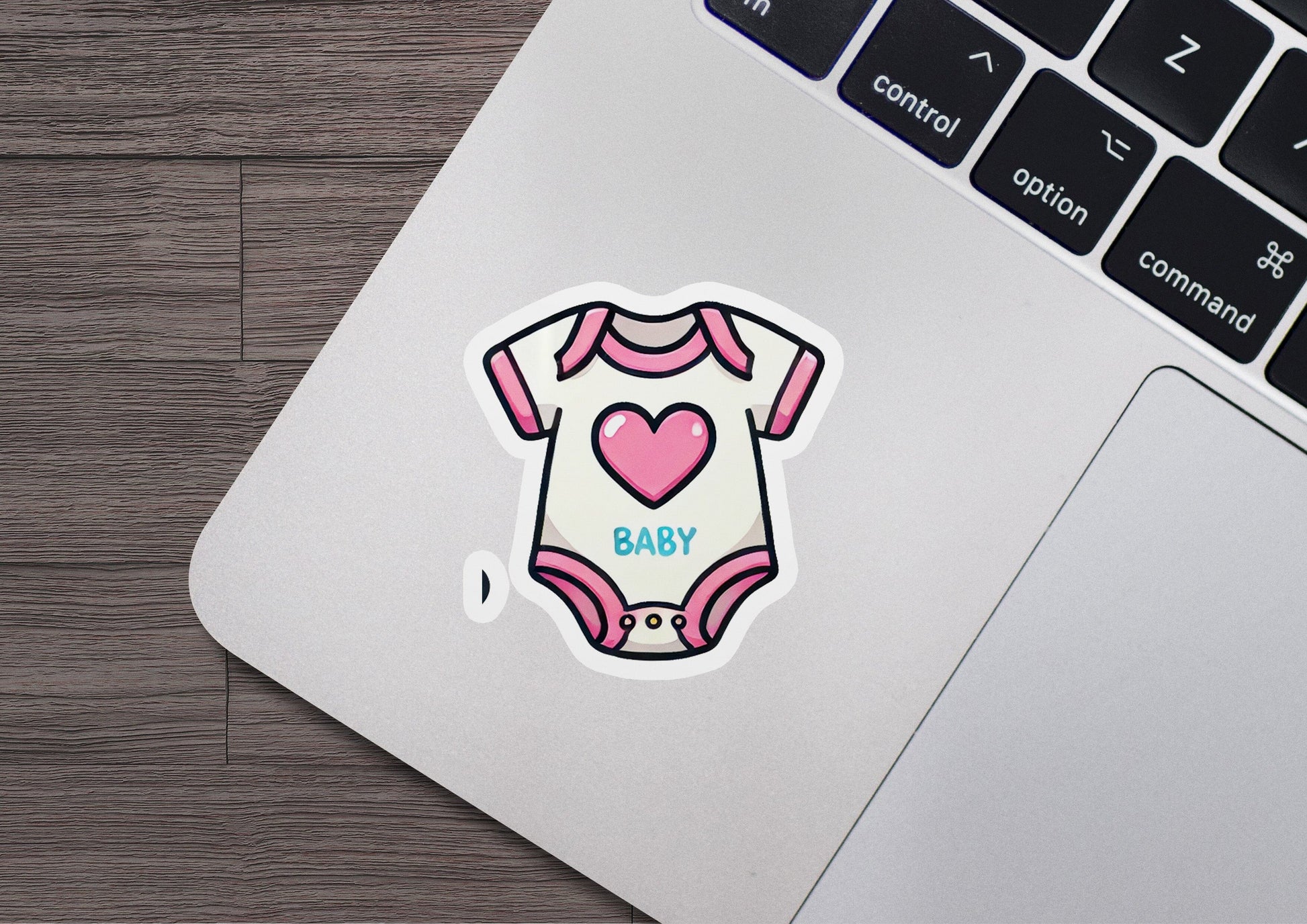 a laptop with a sticker of a baby's bodysuit