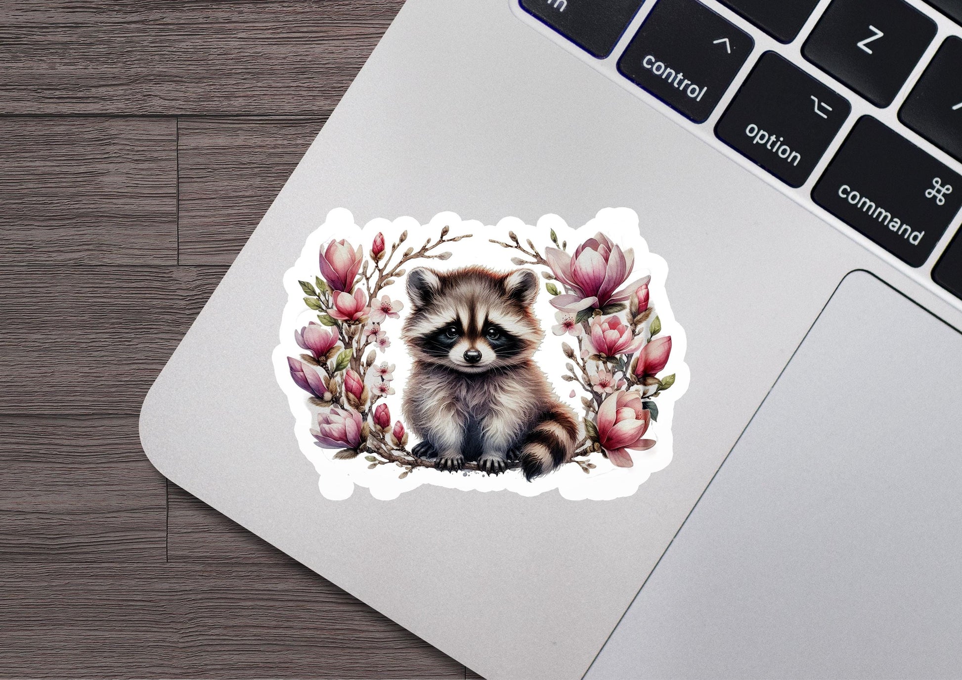a sticker of a raccoon sitting on top of a laptop