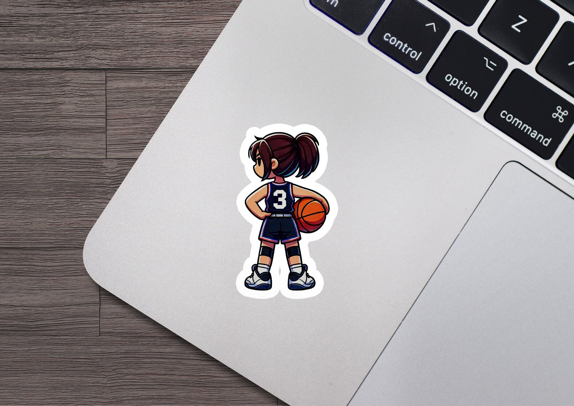 a laptop with a sticker of a girl holding a basketball