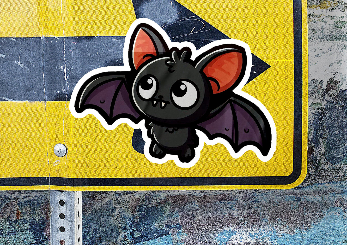 a close up of a street sign with a bat sticker on it