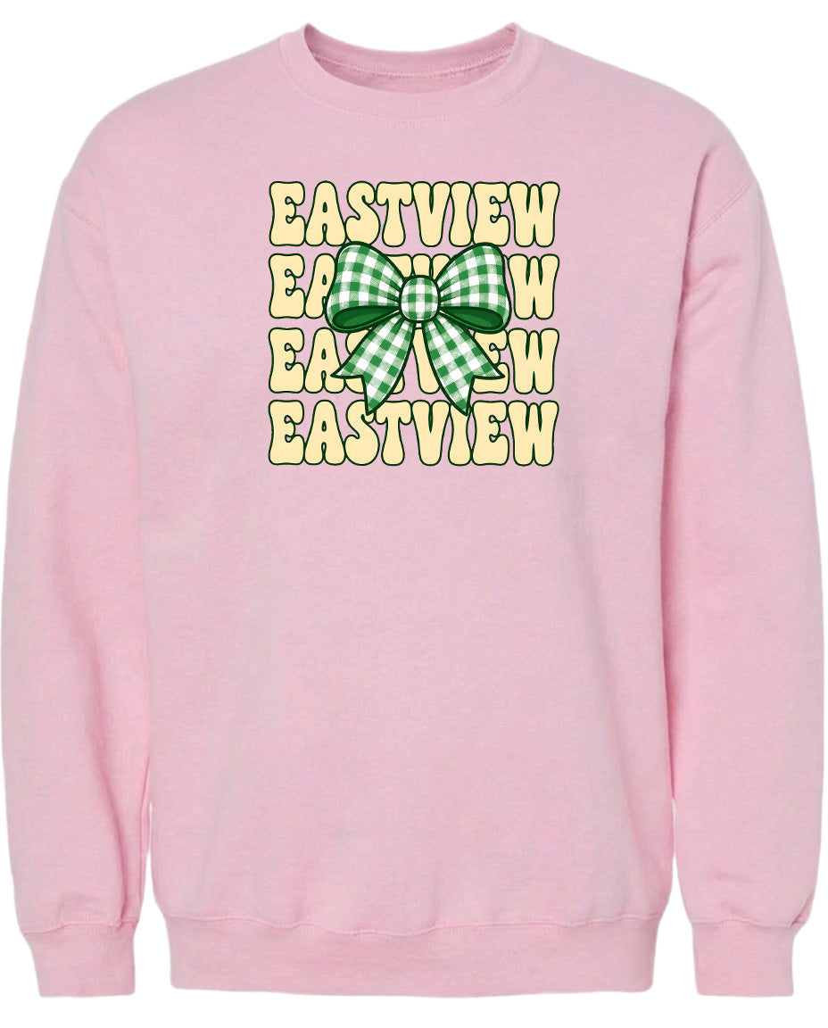 A pink sweatshirt with a graphic design featuring a green and white checkered bow on the front.