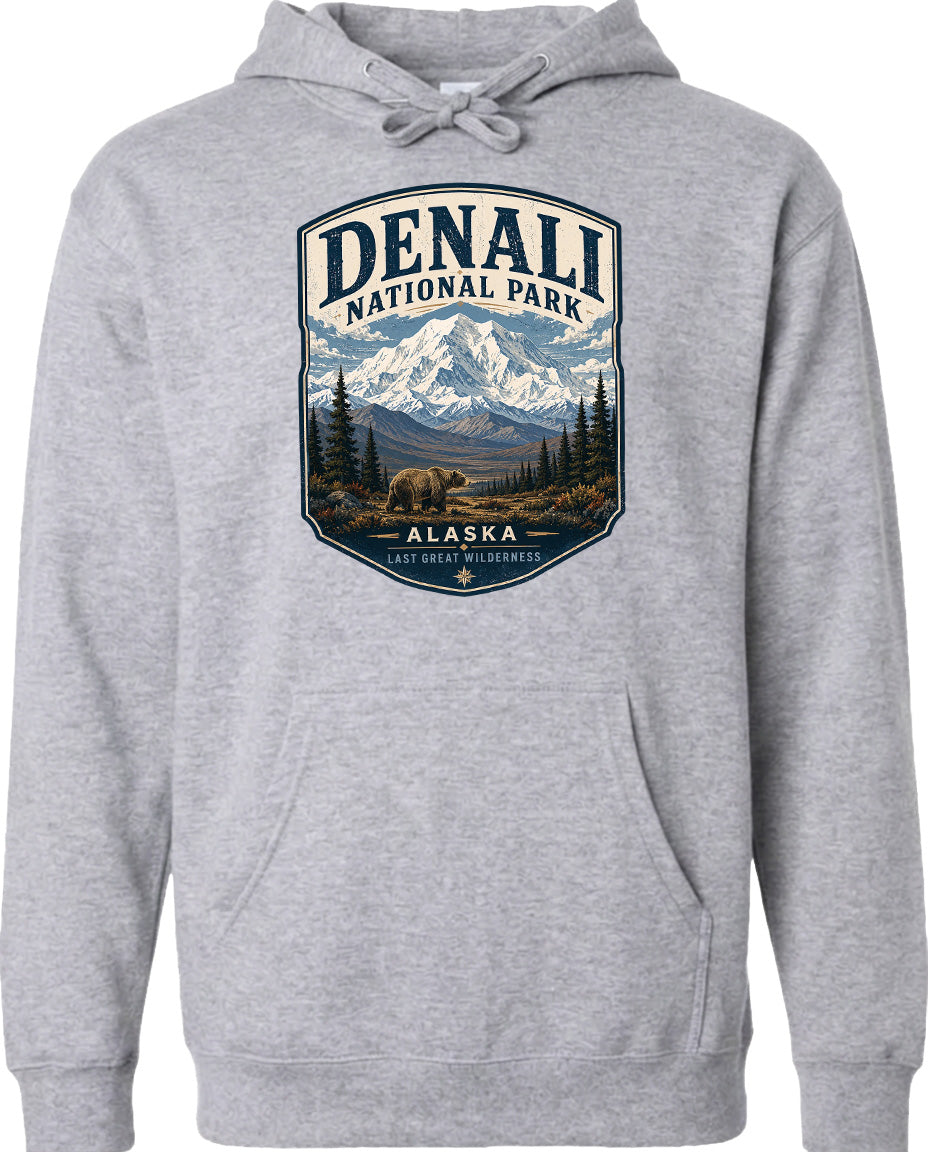 A gray hoodie with a graphic design depicting Denali National Park in Alaska, featuring a mountain landscape with a bear in the foreground.
