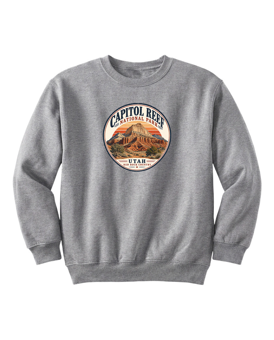 A gray sweatshirt with a circular logo featuring an image of a mountain and the text "CAPITOL REEF NATIONAL PARK UTAH" printed on it.