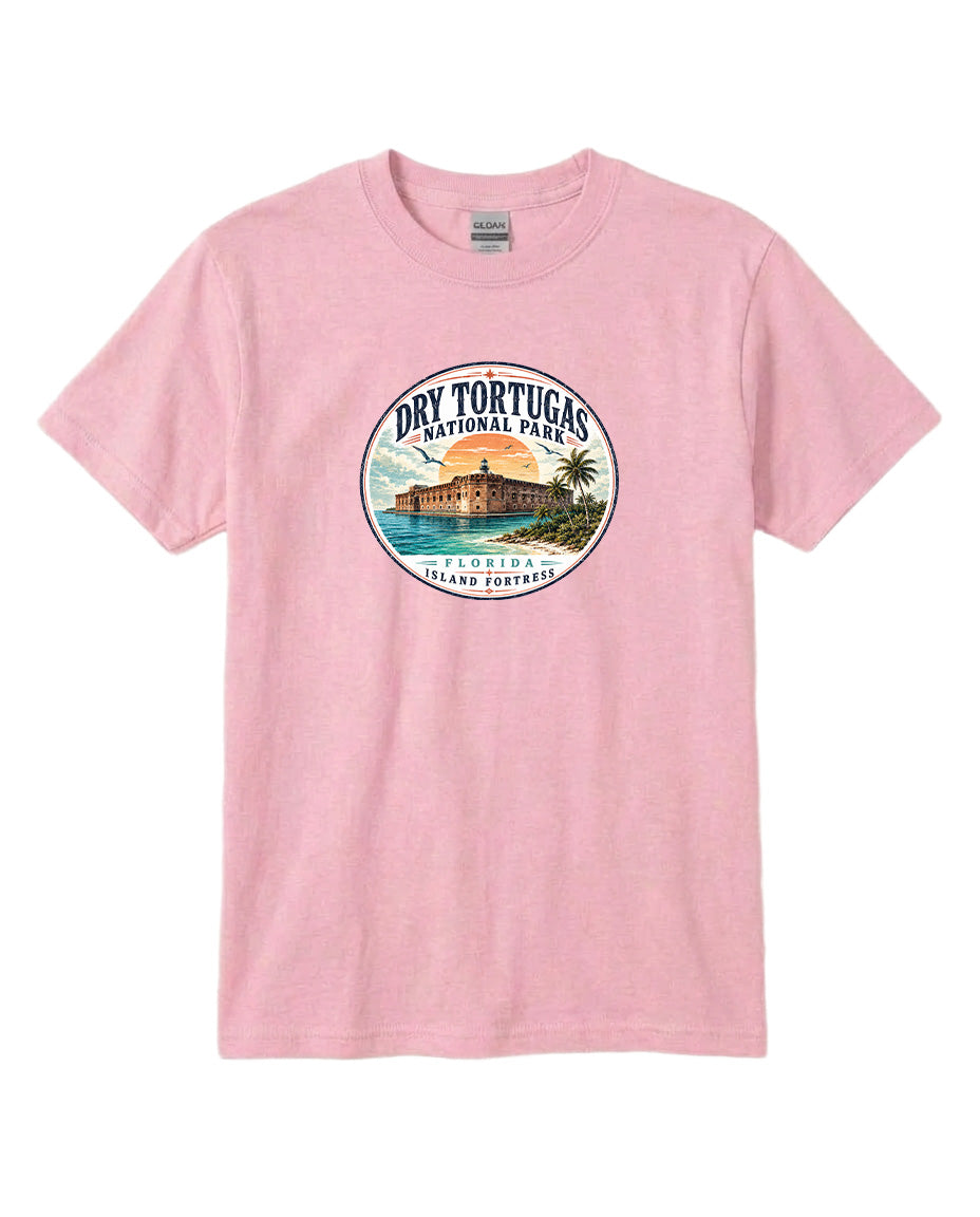 A pink t-shirt with a circular graphic design featuring a beach scene and a building, representing Dry Tortugas National Park in Florida.