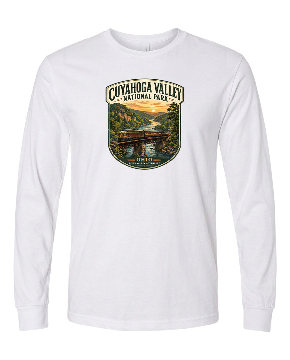 A white long-sleeved t-shirt with a graphic design depicting a scenic view of the Cuyahoga Valley National Park, featuring a bridge, trees, and a sunset.