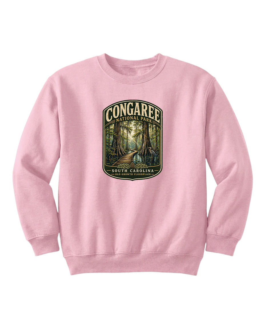 A pink sweatshirt with a graphic design depicting a forest path leading through Congaree National Park in South Carolina.