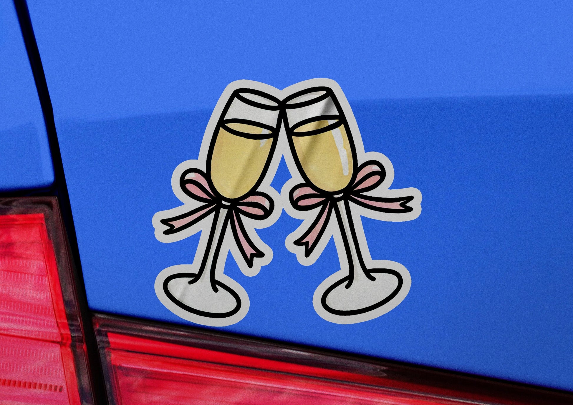 a pair of champagne flutes sticker on the back of a car