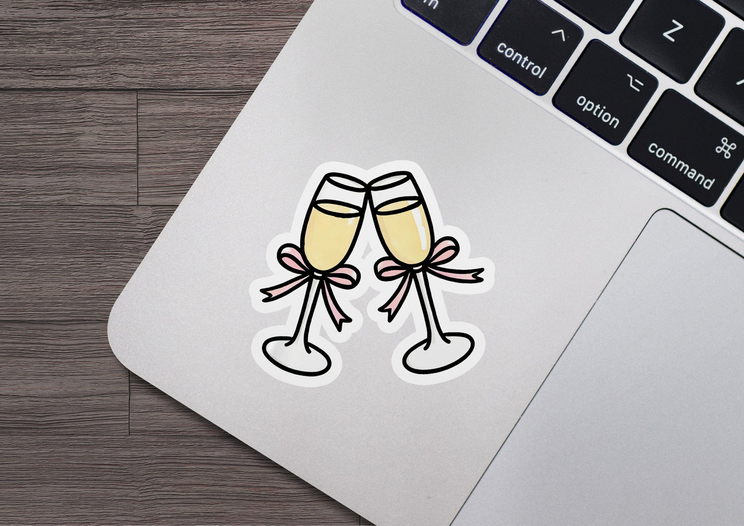 two glasses of champagne sticker on a laptop keyboard
