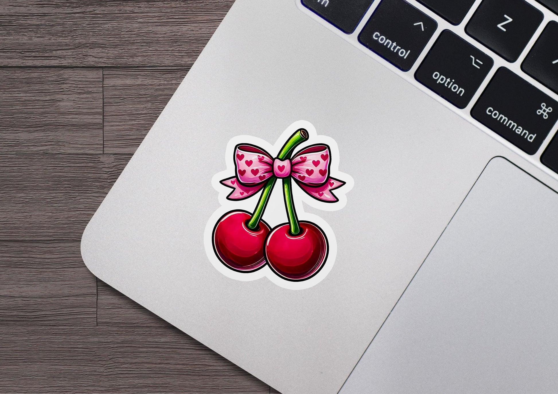 a sticker of a cherry with a bow on it
