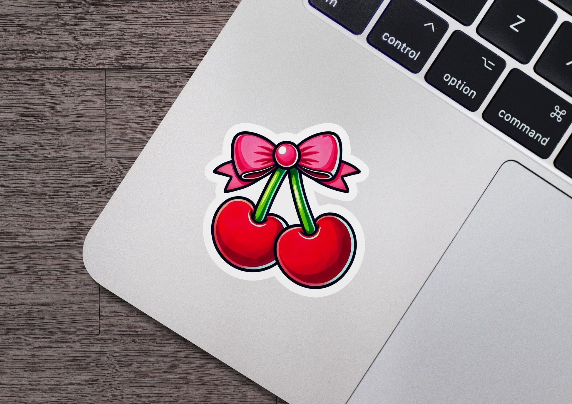 a sticker of two cherries with a bow