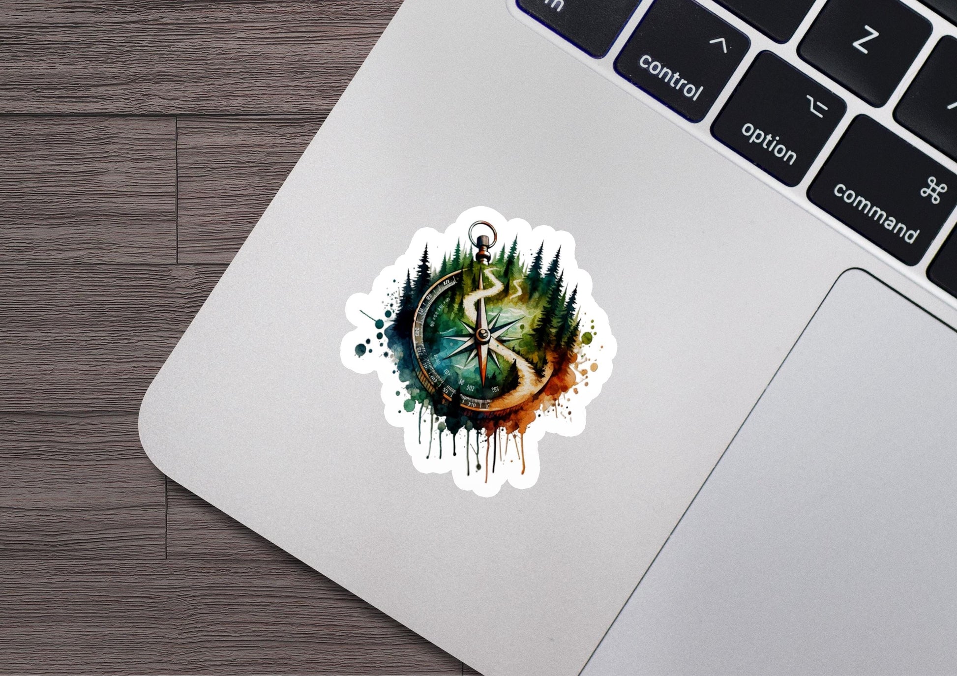a laptop with a sticker of a tree and a compass on it