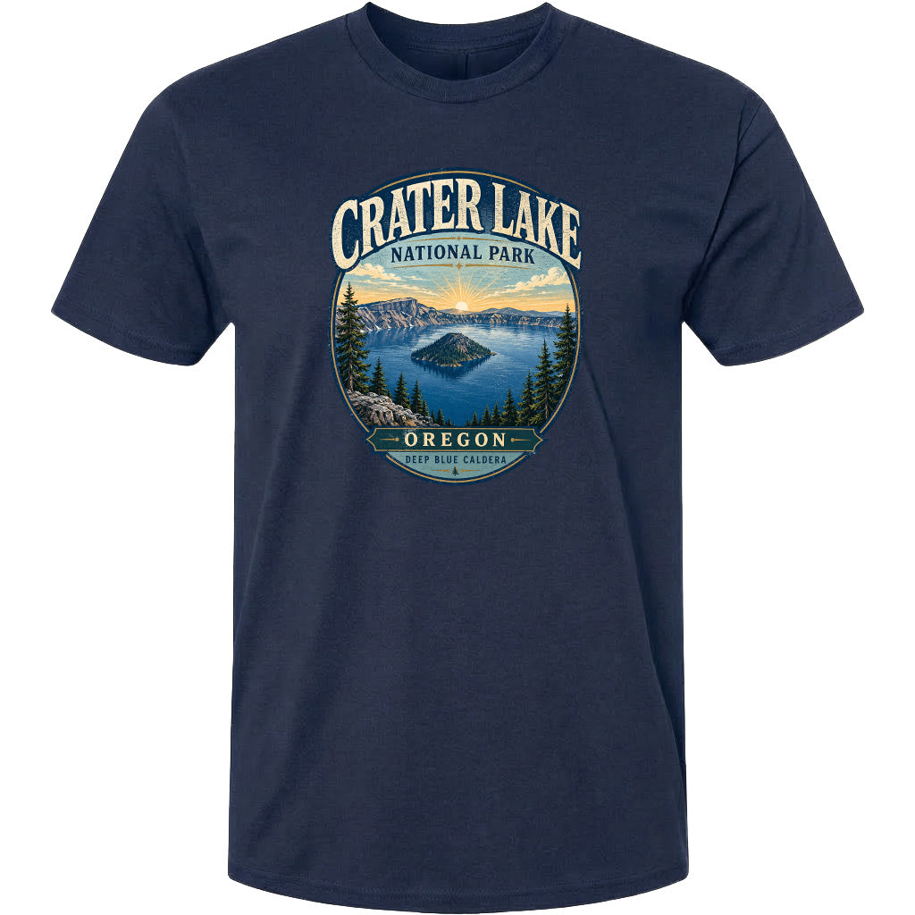 A navy blue t-shirt with a graphic design depicting Crater Lake National Park in Oregon, featuring a scenic landscape with a lake, mountains, and pine trees.