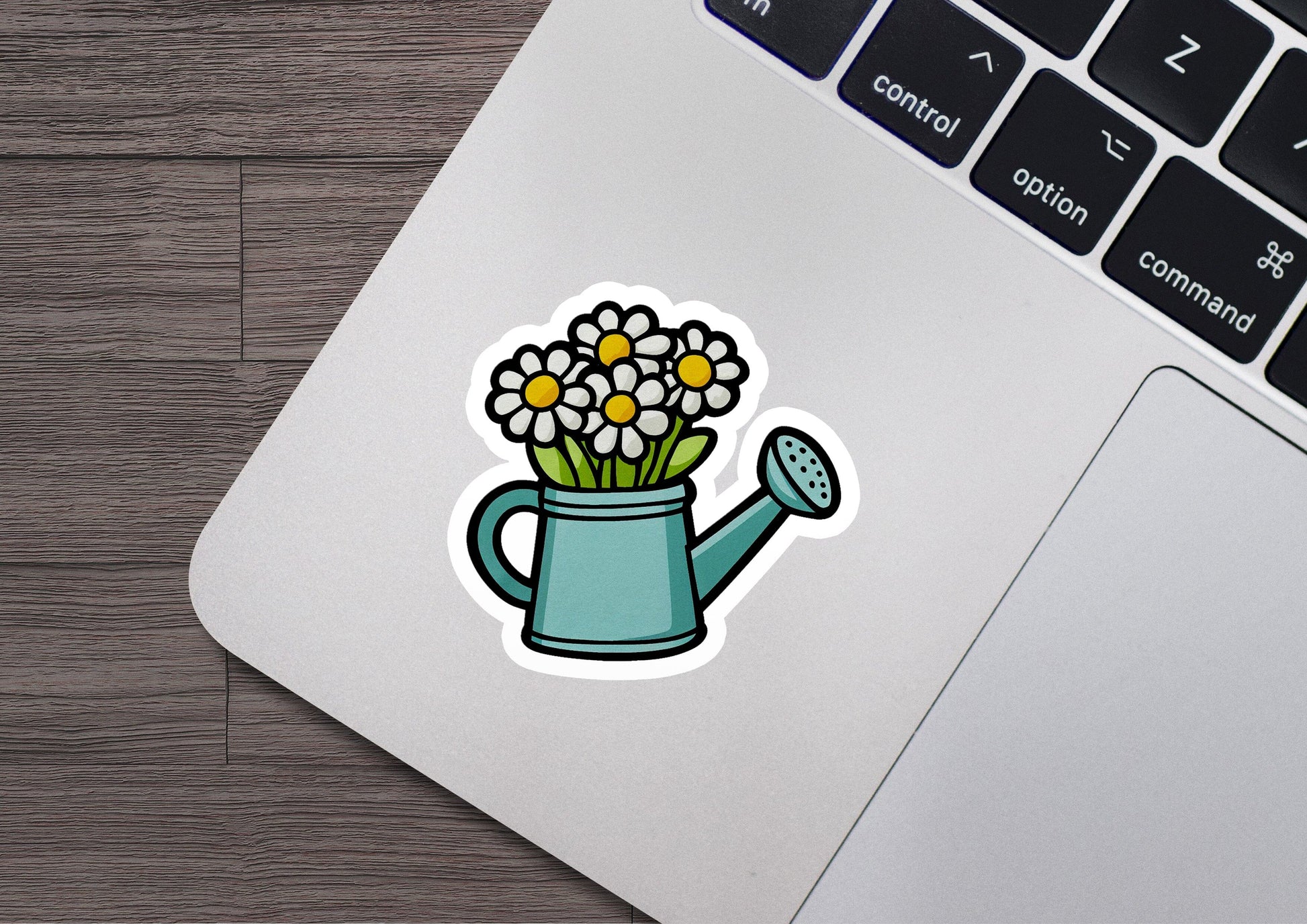 a laptop with a sticker of a watering can with flowers