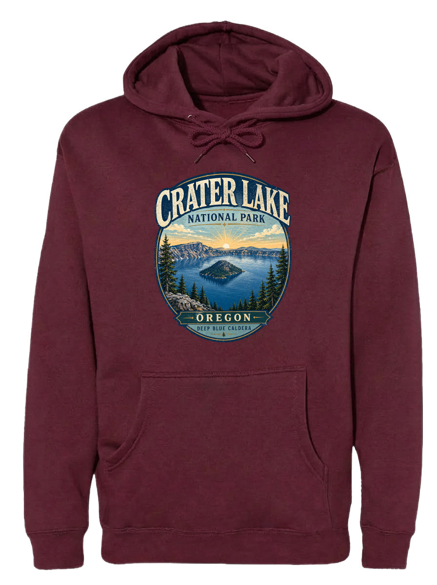 A burgundy hoodie with a graphic design depicting Crater Lake National Park in Oregon, featuring a scenic landscape with a lake, mountains, and forests.