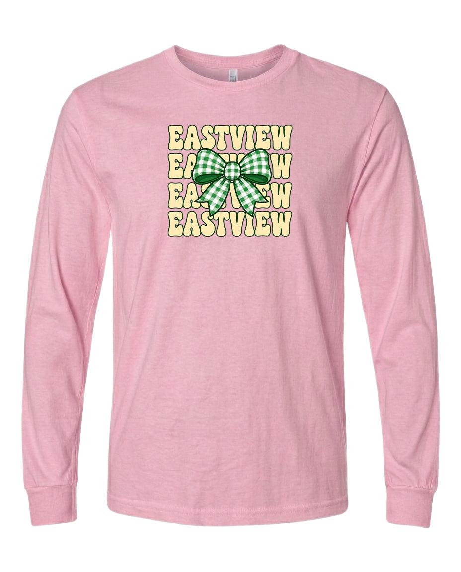 A pink long-sleeved t-shirt with a graphic design featuring a green and white bow and the text "EASTVIEW" repeated multiple times in a vertical pattern.