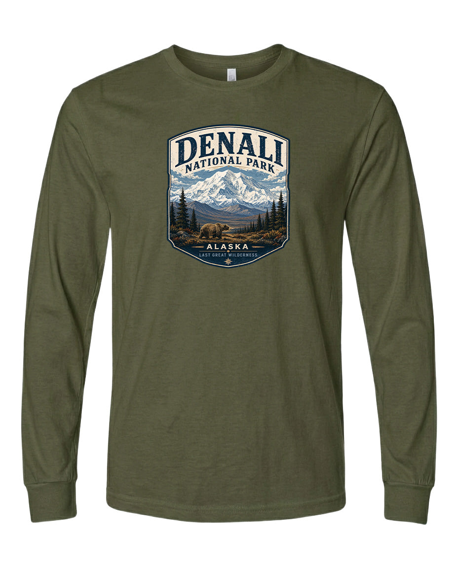 A long-sleeved olive green t-shirt with a graphic design featuring a mountain landscape and the text "DENALI NATIONAL PARK ALASKA LAST GREAT WILDERNESS".